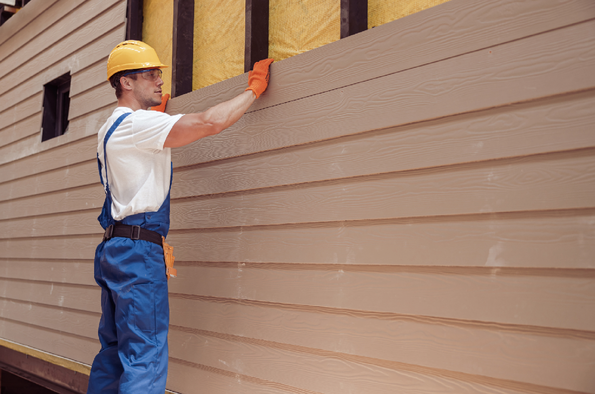 Man installing siding on a house