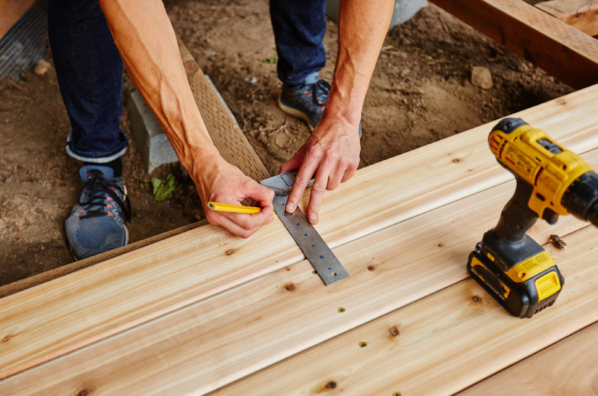 a man measuring while installing a deck