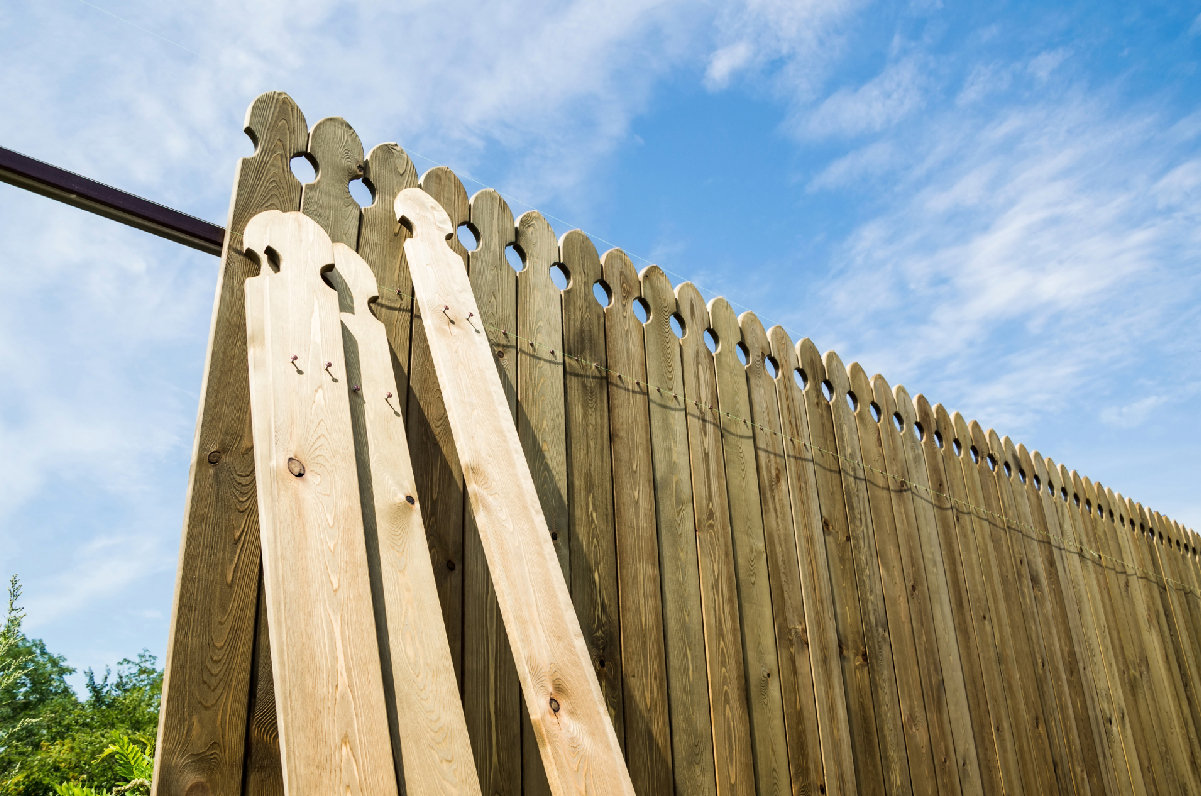 a wooden fence with posts being installed